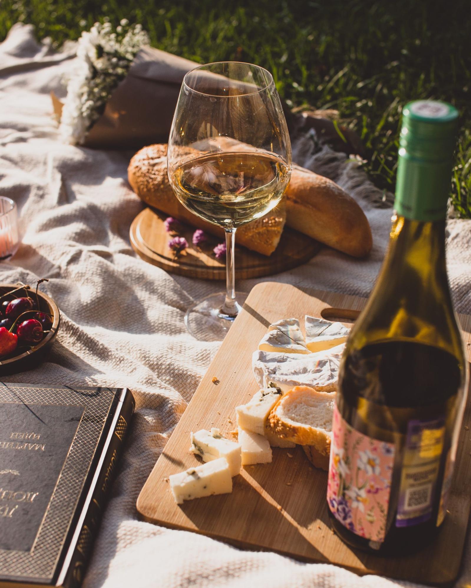 Picnic set up with cheese, baguette and wine